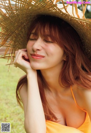 A woman in a yellow dress and a straw hat.