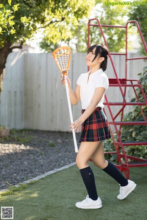 A woman in a school uniform holding a baseball bat.