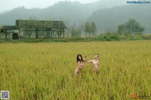 A naked woman standing on top of a wooden structure.