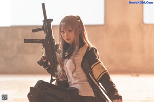 A woman in a black and yellow outfit holding a gun.