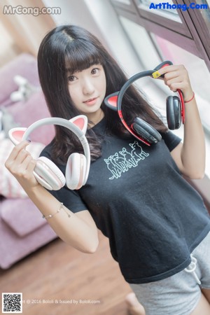 A woman wearing a white shirt and a pair of headphones.