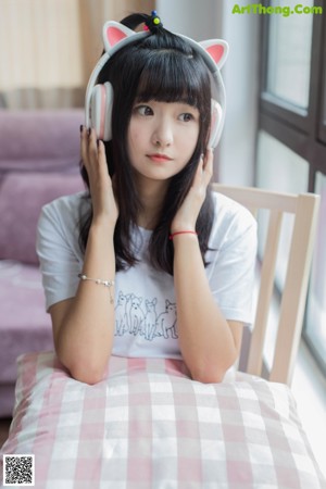 A woman sitting on a bed holding a stuffed animal.