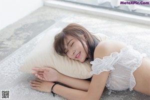 A woman sitting on top of a bed with her feet up.