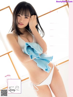 A woman in a white bikini posing for a magazine.