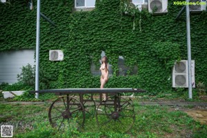 A naked woman standing on top of a wooden table.