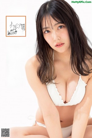 A woman in a white bikini posing for a picture.
