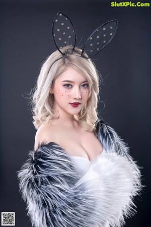 A woman in a fur coat with bunny ears on her head.