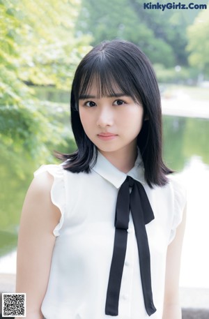 A young woman holding a red lollipop in her hand.