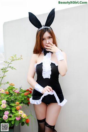 A woman in a white shirt and black skirt posing for a picture.