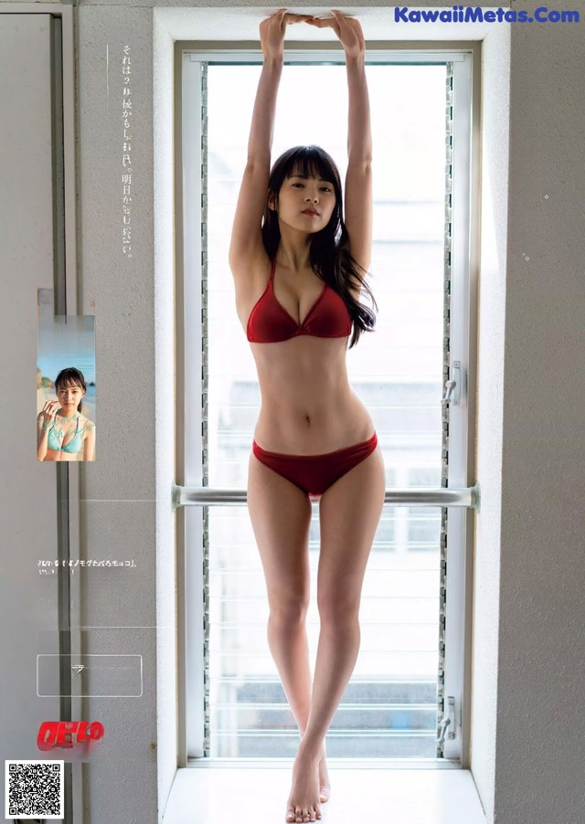 A woman in a red bikini standing by a window.