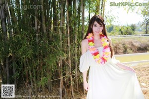 A woman in a white dress sitting on some steps.