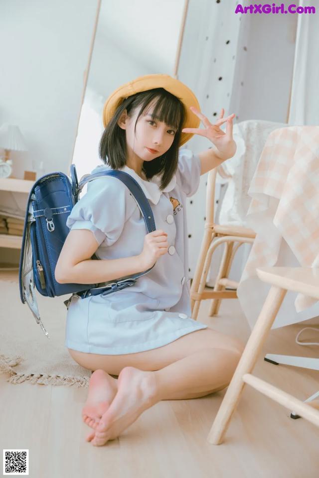 a woman sitting on the floor with a backpack