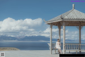A woman sitting on a wooden bench with a mirror.