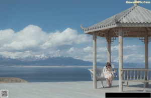 A woman in a white dress holding an umbrella.