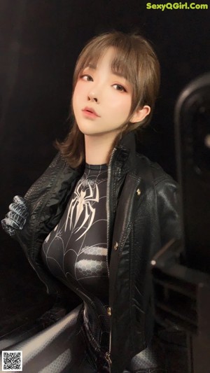 A woman in a black and silver spider suit taking a selfie.