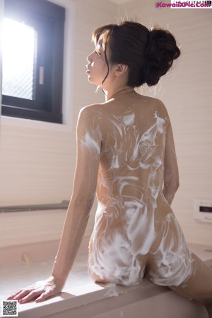 A woman in a leopard print bikini taking a shower.
