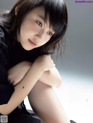 A woman laying on top of a white table.