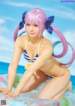 A woman in a bikini and sunglasses on a beach.