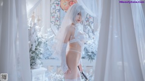 A woman in a white lingerie posing for a picture.